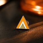 Geometric Orange Triangle Enamel Pin — angled detail view